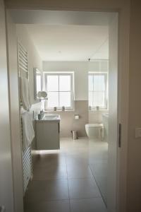 a bathroom with a sink and a toilet and a mirror at Ferienwohnung Vogelsang in Saalhausen
