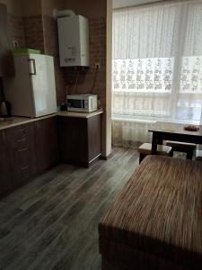 a kitchen with a refrigerator and a table and a microwave at Apartment complex Parklend in Kyiv