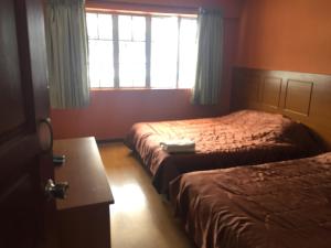 a hotel room with two beds and a window at Golden Night Hotel Cameron Highlands in Cameron Highlands