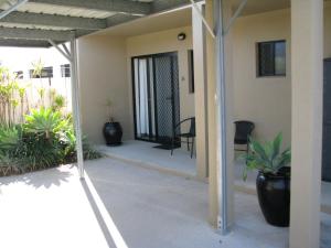 a view from the outside of a house with plants at Charm City Motel in Bundaberg