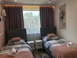 two beds in a room with a window with towels on them at Family & Business Sauna Apartments No1 Leśny nad Zalewem Cedzyna Unikat - 3 Bedroom with Private Sauna, Bath with Hydromassage, Terrace, Garage, Catering Options in Kielce