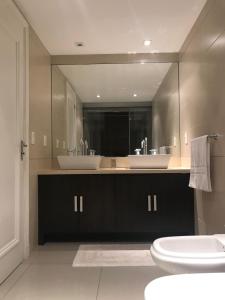 baño con 2 lavabos y espejo grande en IMPERIALE Luxury Apartment, en Punta del Este