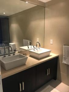 baño con 2 lavabos y espejo grande en IMPERIALE Luxury Apartment, en Punta del Este