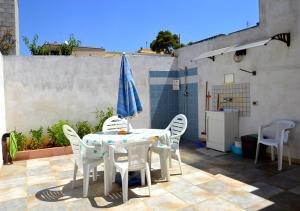 Villetta Anna في توري فادو: طاولة مع كراسي ومظلة على الفناء