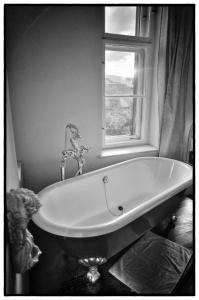 a bath tub in a bathroom with a window at Hotel Mariandl in Munich