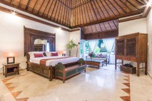 a bedroom with a bed and a living room at Casa Jimbaran Villa in Jimbaran