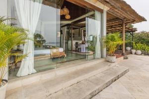 a bedroom in a villa with glass walls at Casa Jimbaran Villa in Jimbaran