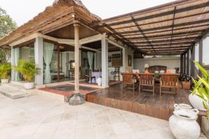 a patio with a wooden deck with a dining table at Casa Jimbaran Villa in Jimbaran