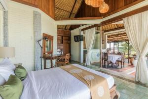 a bedroom with a bed and a dining room at Casa Jimbaran Villa in Jimbaran