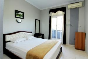 سرير أو أسرّة في غرفة في Hotel Bugis Asri