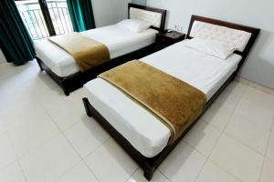 سرير أو أسرّة في غرفة في Hotel Bugis Asri