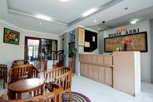 a restaurant with a table and chairs and a counter at Hotel Bugis Asri in Yogyakarta