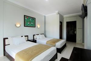 سرير أو أسرّة في غرفة في Hotel Bugis Asri