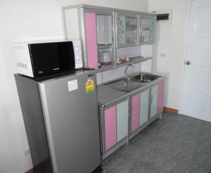 una piccola cucina con frigorifero e forno a microonde di VIP Condochain Rayong a Ban Phe