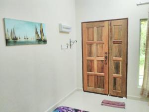 um quarto com uma porta e um quadro na parede em Homestay Pulau Langkawi em Pantai Cenang