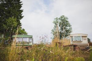Dois trailers estacionados um ao lado do outro num campo. em Domki nad jeziorem Mieruniszki em Filipów