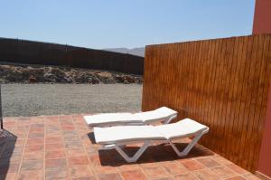 Tuineje的住宿－Estudio Rural La Rosa Herrera，庭院里设有三把白色躺椅