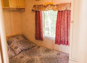 a small room with a bed and a window at Domki nad jeziorem Mieruniszki in Filipów