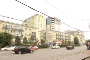 a street with cars parked in front of a building at Khongor Guest house & Tours in Ulaanbaatar
