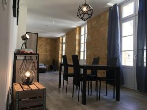 uma sala de jantar com uma mesa e cadeiras pretas em Les lumières de Sarlat em Sarlat-la-Canéda