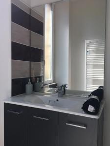 a bathroom with a sink and a mirror at Les lumières de Sarlat in Sarlat-la-Canéda