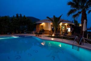 a swimming pool in front of a house at night at Hotel Grand Nefeli in Vasiliki