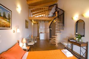 a living room with a spiral staircase and a kitchen at Hotel Grand Nefeli in Vasiliki