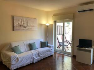Il comprend un salon doté d'un canapé blanc et d'un balcon. dans l'établissement LA CASA DI ANDREA, à Taormine
