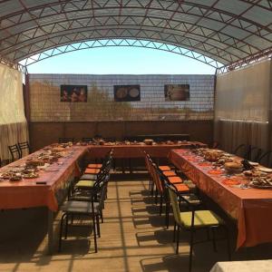 a large room with long tables and chairs in it at AltynAi Guest House in Cholpon-Ata