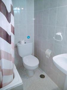 a white toilet sitting next to a sink in a bathroom at Hostal Esmeralda in Madrid