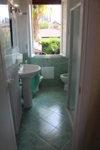 een badkamer met een wastafel en een toilet en een raam bij Brezza di Lago in Salò +29 foto's