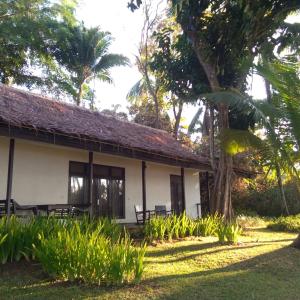 ein weißes Gebäude mit Bänken davor in der Unterkunft Kuda Laut Resort in Cisolok