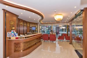 a restaurant with a bar with red chairs and a counter at Marcello Hotel in Istanbul