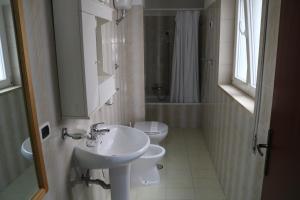 a white bathroom with a sink and a toilet at Le Tre Rose Bed & Breakfast in Casamassima +74 photos