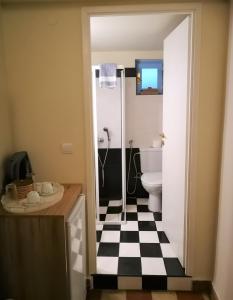 a bathroom with a black and white checkered floor at Apollon Hotel in Chania