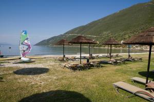 a group of chairs and umbrellas on a beach at Hotel Grand Nefeli in Vasiliki