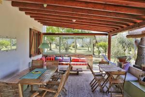 a living room with wooden tables and chairs at Nômade - Slow Living Lodge in Balestrate
