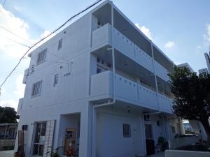 ein weißes Gebäude mit einer Seitentreppe in der Unterkunft Guesthouse Sea Turtle in Miyako-jima