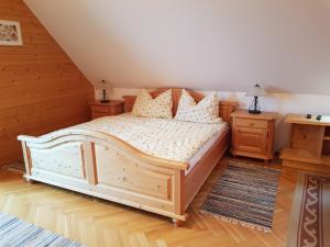 a bedroom with a wooden bed and two night stands at Schweighofers Almhaus in Heilbrunn