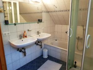 a bathroom with two sinks and a tub and a mirror at Schweighofers Almhaus in Heilbrunn