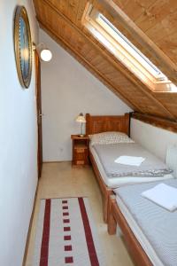 a attic bedroom with two beds and a window at Blažkův Statek in Malšice