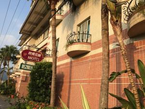 a brick building with a sign for a hotel motel at Rose Garden Motel in Qishan