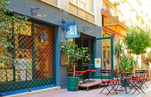 ein Café mit Tischen und Stühlen außerhalb eines Gebäudes in der Unterkunft Athens Connection Apartments in Athen