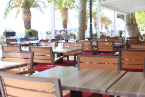 an empty restaurant with tables and chairs and palm trees at Apartment Andrija in Baška Voda