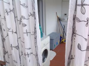 een wasruimte met een wasmachine en een gordijn bij Utoring cellaio in Ischia