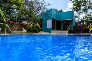 a swimming pool in front of a blue building at Fig Tree Residences in Dar es Salaam