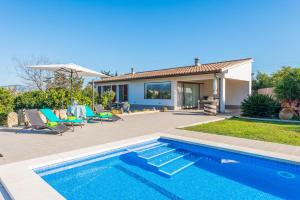 a villa with a swimming pool and a house at Es Serral in Sa Pobla