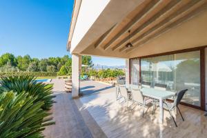 une terrasse avec une table et des chaises blanches dans l'établissement Es Serral, à Sa Pobla