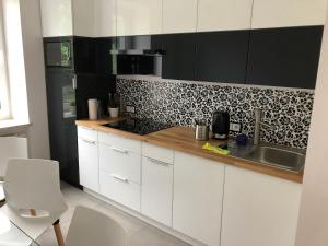 una cucina con mobili bianchi e un lavandino di Pokoje ANTRACYT a Skarżysko-Kamienna