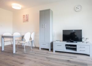 uma sala de estar com uma televisão e uma mesa com cadeiras em Am Roten Kreuz 11, Winterberg-Zuschen em Winterberg